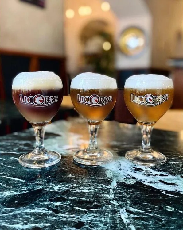 Trois verres de bière Licorne sur une table en marbre vert